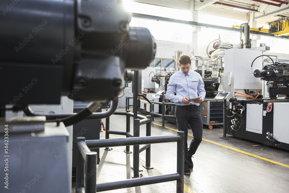 Man with tablet walking in factory shop floor Man with tablet walking in factory shop floor