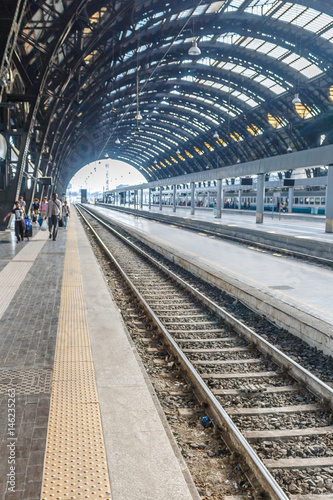 Conceptual image of european railway station and Commuters on platform in Italy