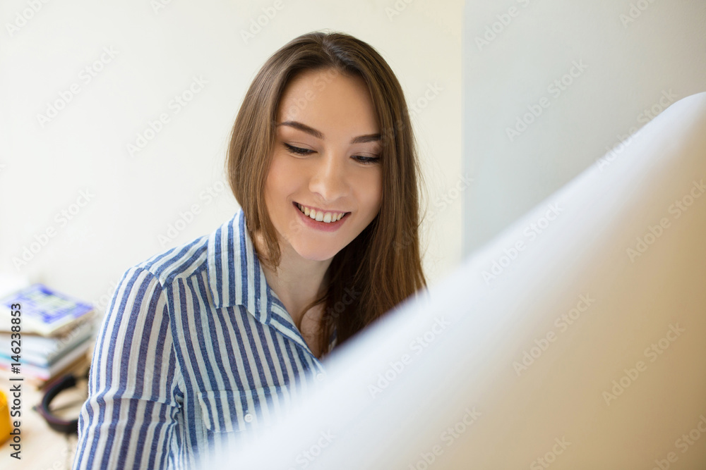 Smiling girl standing with a marker near a whiteboard and drawing. Business, startup, planning, happy woman start writing on a flipchart Smiling girl standing with a marker near a whiteboard and drawing. Business, startup, planning, happy woman start writing on a flipchart