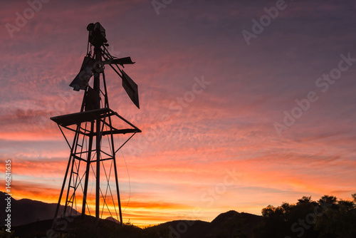 Silhouette of a broken windmill against sunset