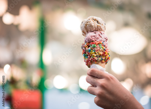 ice cream on rainbow crone on hand with light blurred background