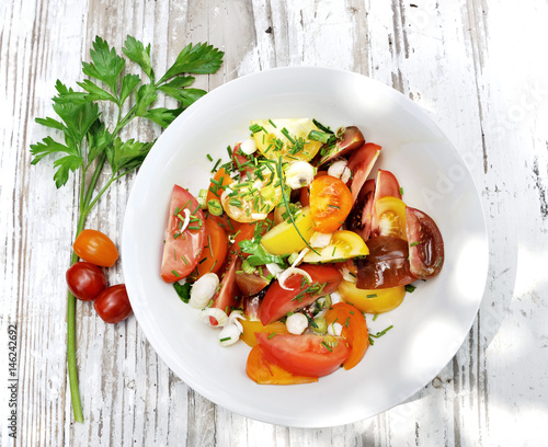 assiette de tomates accompagnées d'herbe sur table