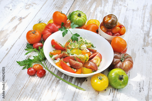 salade de tomates dans assiettes et différentes variétés de tomates entières