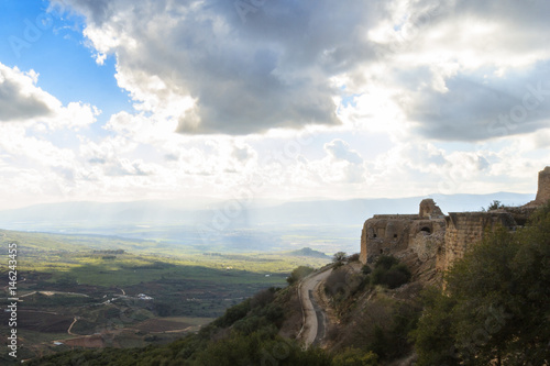 Ancient knights fortress and amazing Upper Galilee mountains view  North Israel. Evening shot. Big grey rain clouds. Sunlight rays and shadows on the hills.