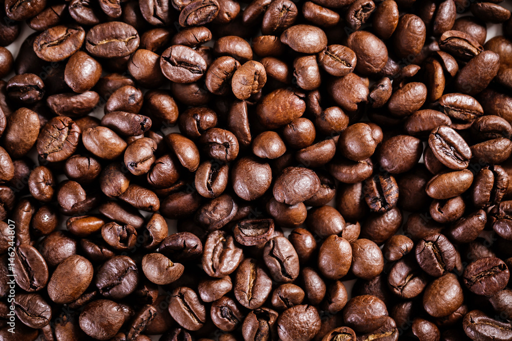 Naklejka premium roasted coffee beans background. brown texture