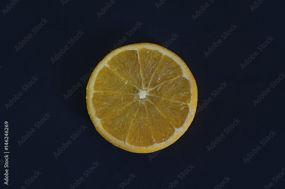 Slice of orange against a dark blue background Slice of orange against a dark blue background