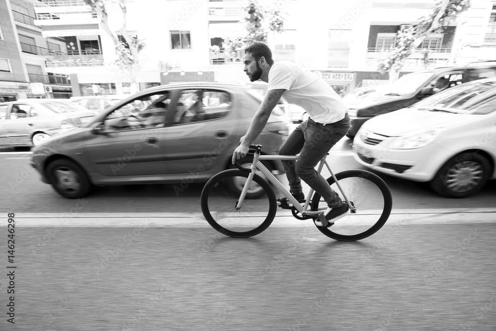 Obraz premium Cyclist man riding fixed gear sport bike in sunny day on a city