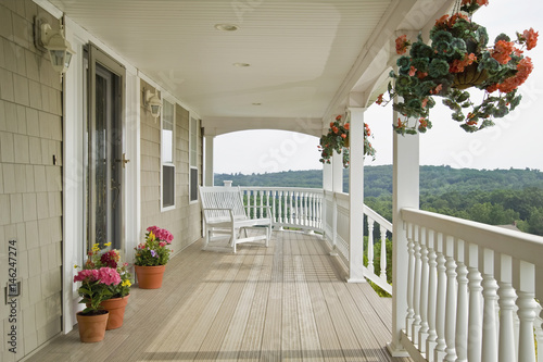Large front porch of shingle style home with great view of tree tops