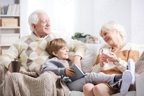 Grandparents reading to grandson photo