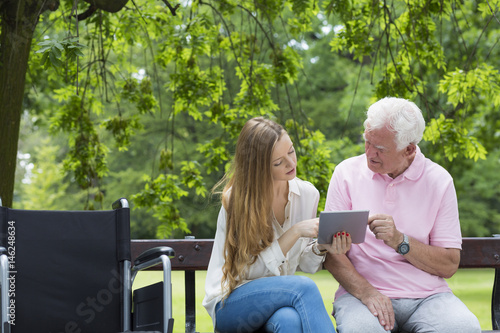 Young girl with the senior using a tablet