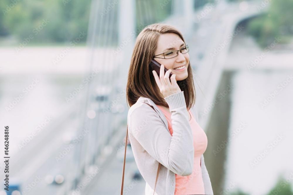 Fototapeta premium Young woman using smartphone outdoor