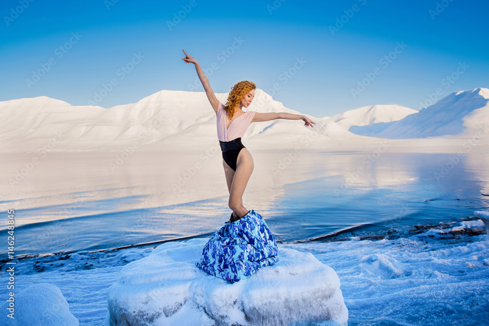 Girl slender beautiful red hair in a body in the frost on a background of mountains svalbard on the Spitsbergen city Longyearbyen , in sunny weather posing as a model Girl slender beautiful red hair in a body in the frost on a background of mountains svalbard on the Spitsbergen city Longyearbyen , in sunny weather posing as a model