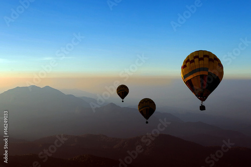 hot-air balloons flying over the mountain at sunrise
