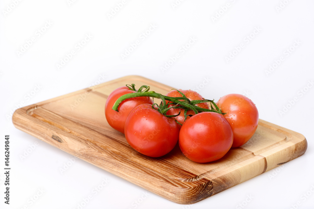 Tomatoes. cherry on vine on cutting board. Isolated on white Tomatoes. cherry on vine on cutting board. Isolated on white