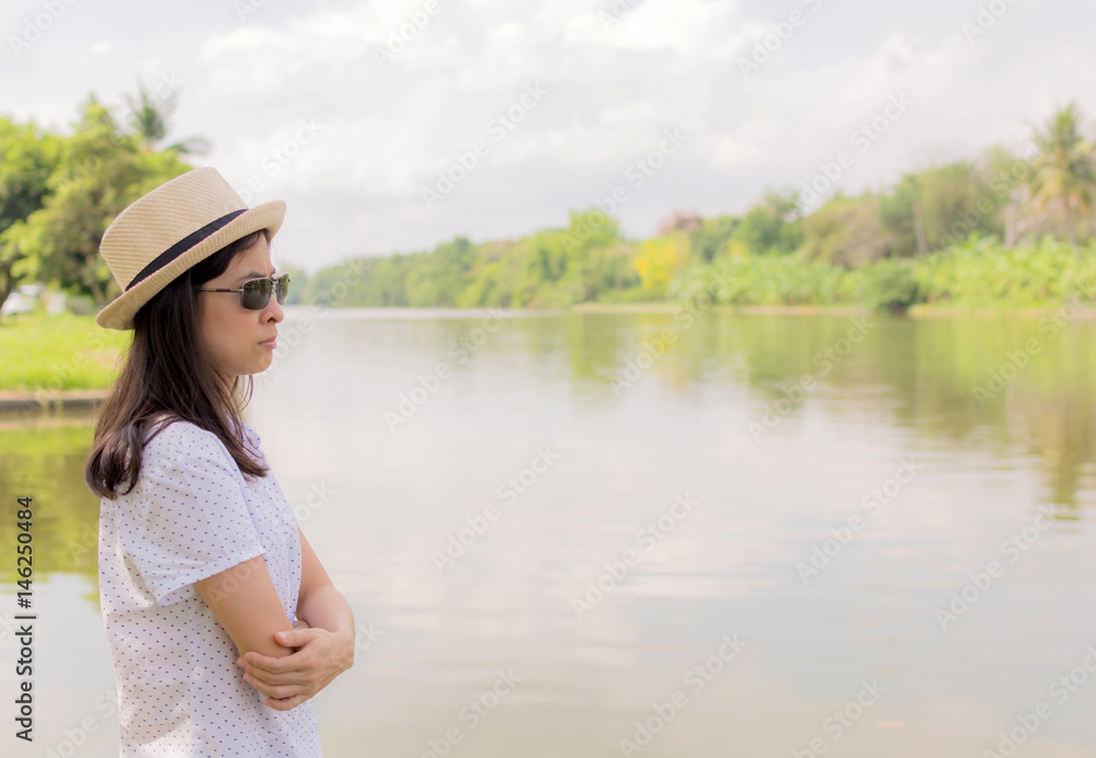 young beautiful woman relaxing in park nearby lake