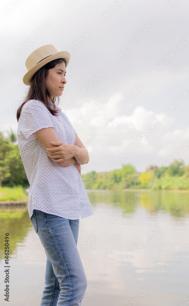 young beautiful woman relaxing in park nearby lake