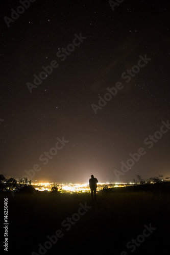Fototapeta Naklejka Na Ścianę i Meble -  photographer shooting the stars over a small mountain town 