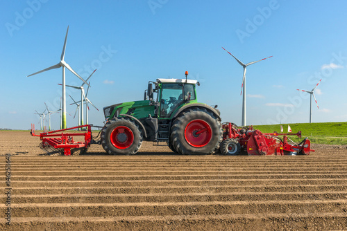 Fototapeta Landtechnik - Traktor auf dem Acker beim Kartoffelanbau - 7099