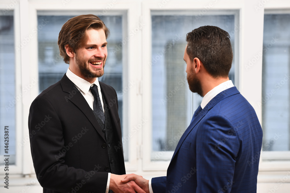 Business partners. Two businessmen smiling and shaking hands Business partners. Two businessmen smiling and shaking hands