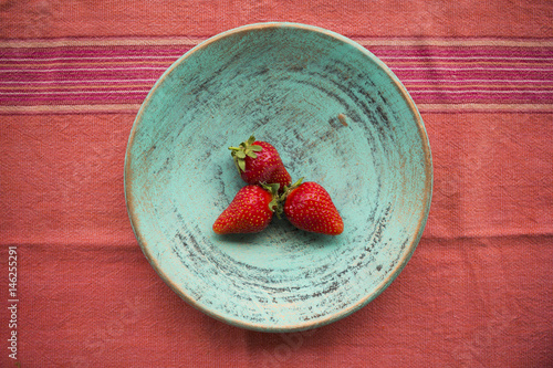 Three strawberries on a plate