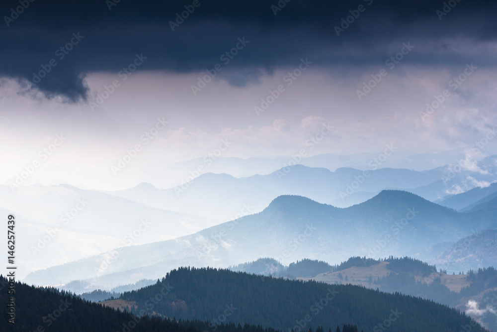 Landscape  of mountains in spring. View of green forest and misty hills.