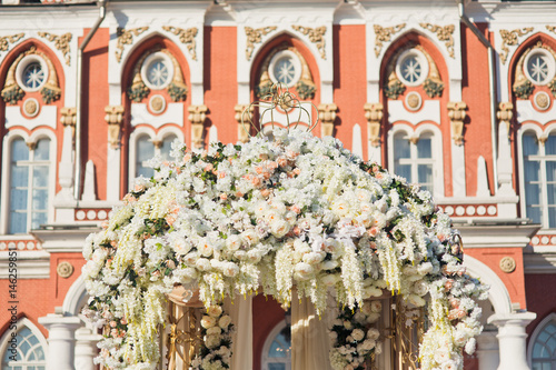 Roof of wedding altar rich decorated with white flowers