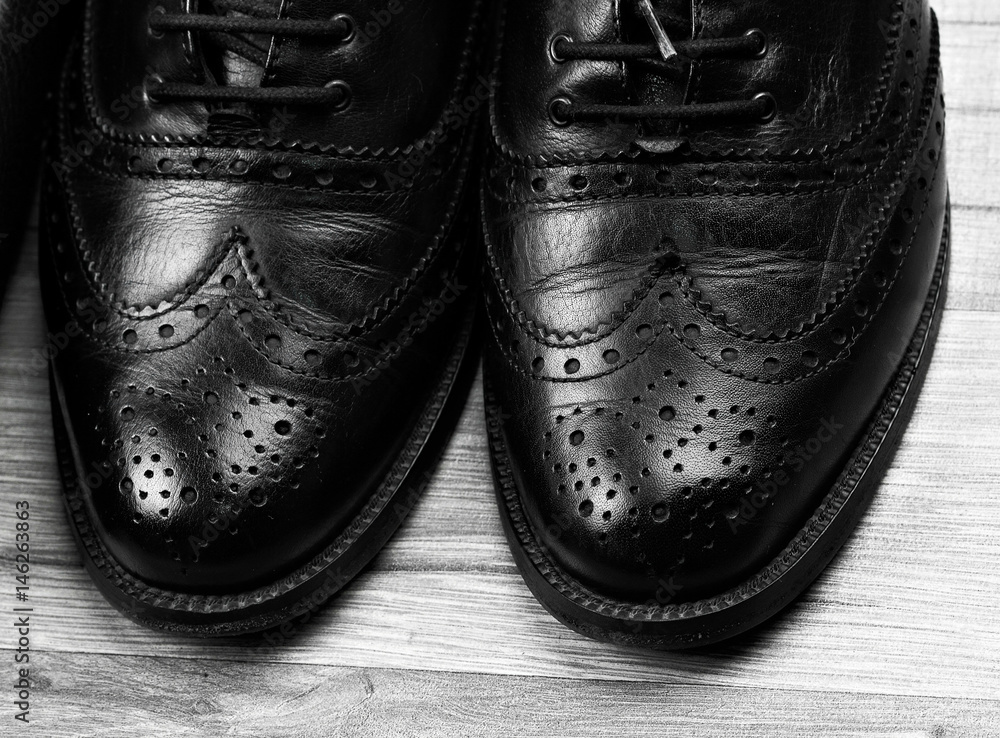 black oxford shoes with shoelace on black background closeup, top view black oxford shoes with shoelace on black background closeup, top view