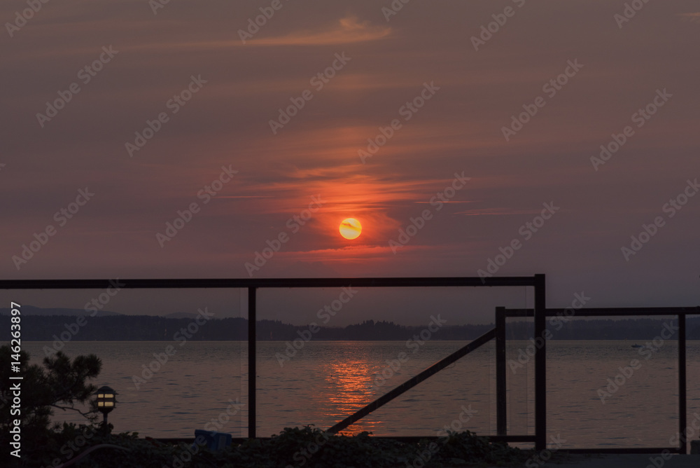Setting sun with glass rail over the sea