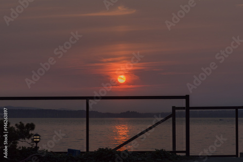 Setting sun with glass rail over the sea