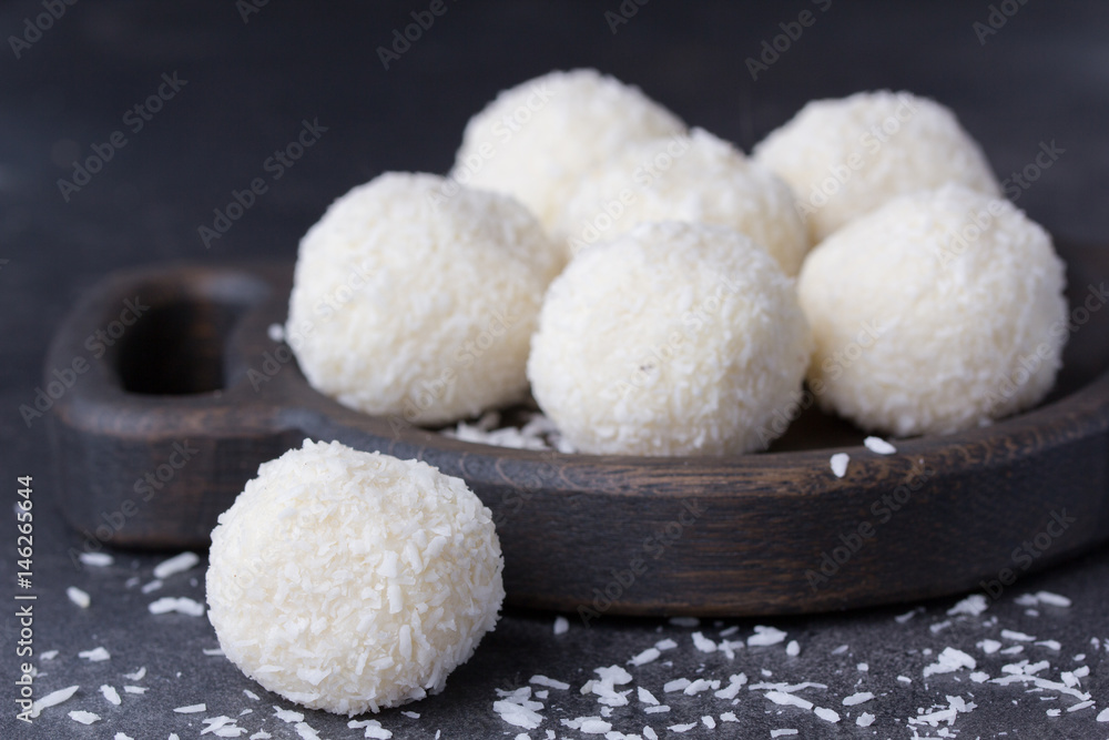 Coconut candy on a wooden board. Round coconut balls