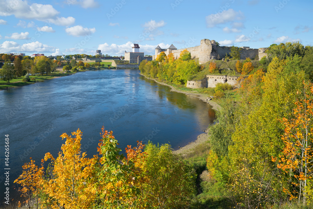 Golden Autumn on the border river Narva. View of the Russian Ivangorod fortress and the Estonian castle of Herman. The border between Estonia and Russia
