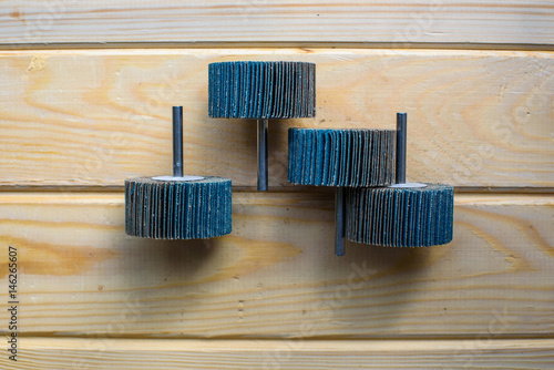 Flap Wheel. A pile of color abrasive Flap Wheel industrial on wood background texture. Great for grinding, metal finishing, sanding steel or inox. sandpaper wheel tool - professional equipment