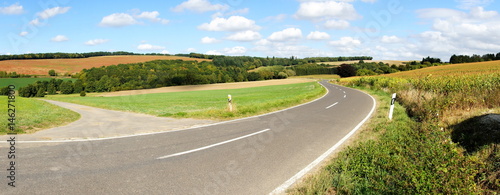 Strasse durch eine farbige Herbstlandschaft bei der Siedlung Maiermund im mittleren Hunsrück Panorama
