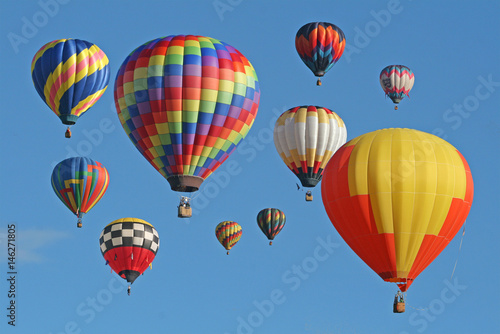 Collection of hot air balloons against a blue sky © Jim Glab