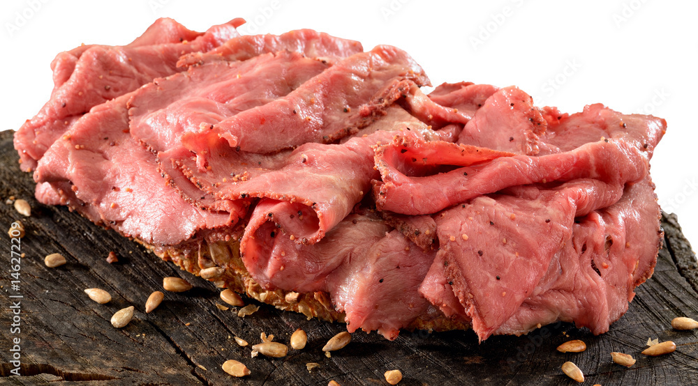 Thinly sliced rare roast beef open sandwich on wholegrain bread. Top isolated on white.