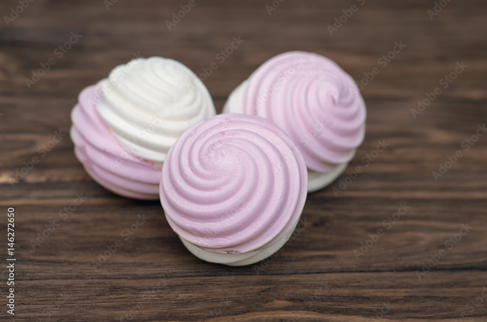 Sweet homemade dessert - berry marshmallow (zephyr) on a plain wooden background Sweet homemade dessert - berry marshmallow (zephyr) on a plain wooden background