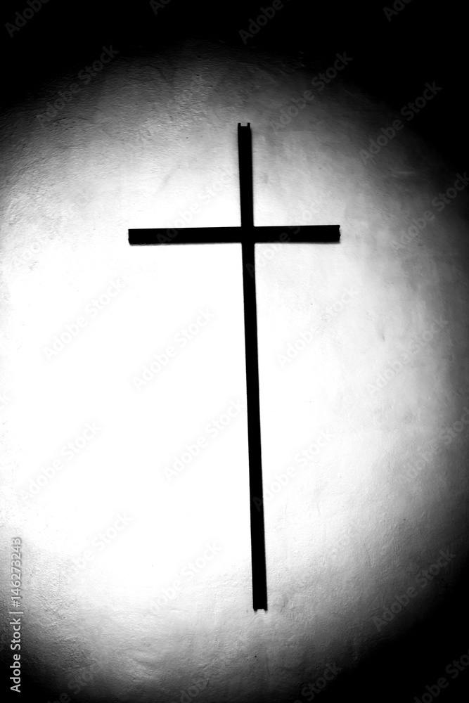 Gruft mit Kreuz  / In eine dunkle Gruft tritt ein Lichtstrahl direkt auf die Mitte eines Kreuzes.