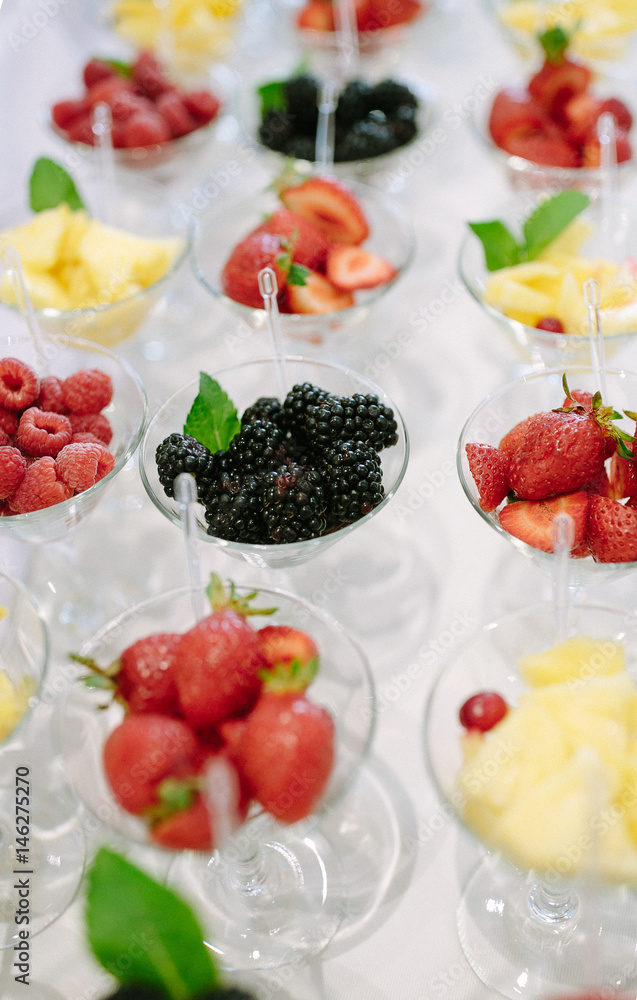 Rows of cocktail glasses with fresh summer fruits and berries prepared for reception Rows of cocktail glasses with fresh summer fruits and berries prepared for reception