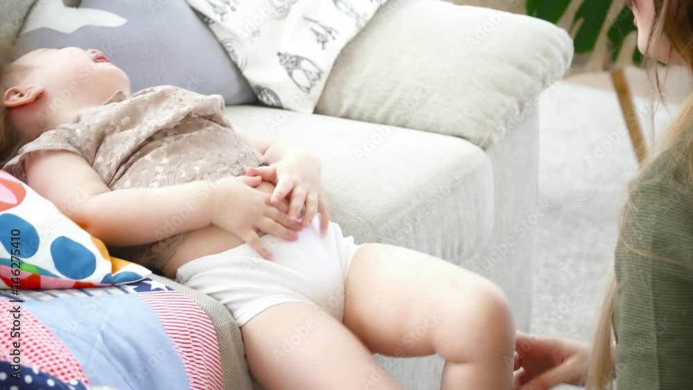 Young mother playing with her daughter on the couch closeup Young mother playing with her daughter on the couch closeup