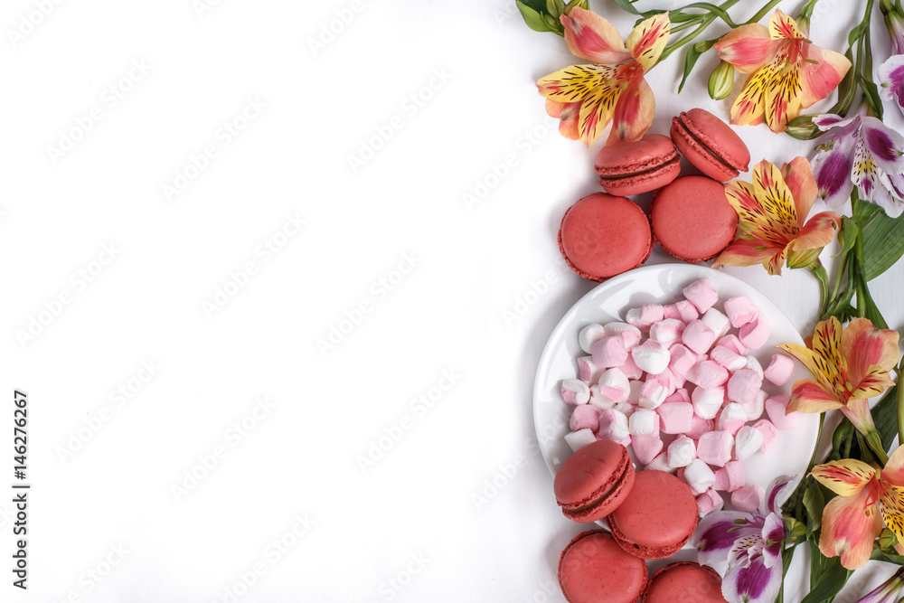 macaroons, marshmallows and flowers Alstroemeria on a white table macaroons, marshmallows and flowers Alstroemeria on a white table