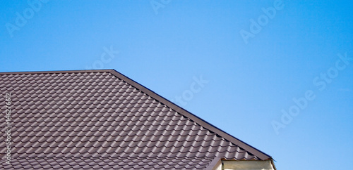 Brown roof of metal roofing on the sky background