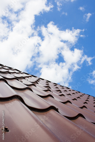 Brown roof of metal roofing on the sky background