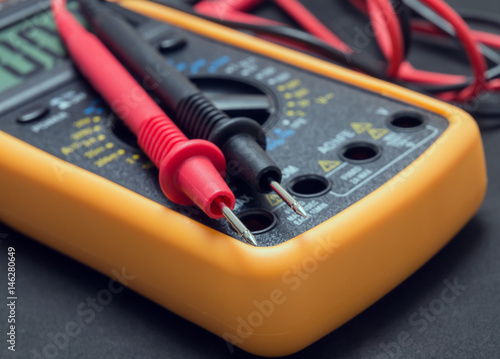 multimeter and tester on black background