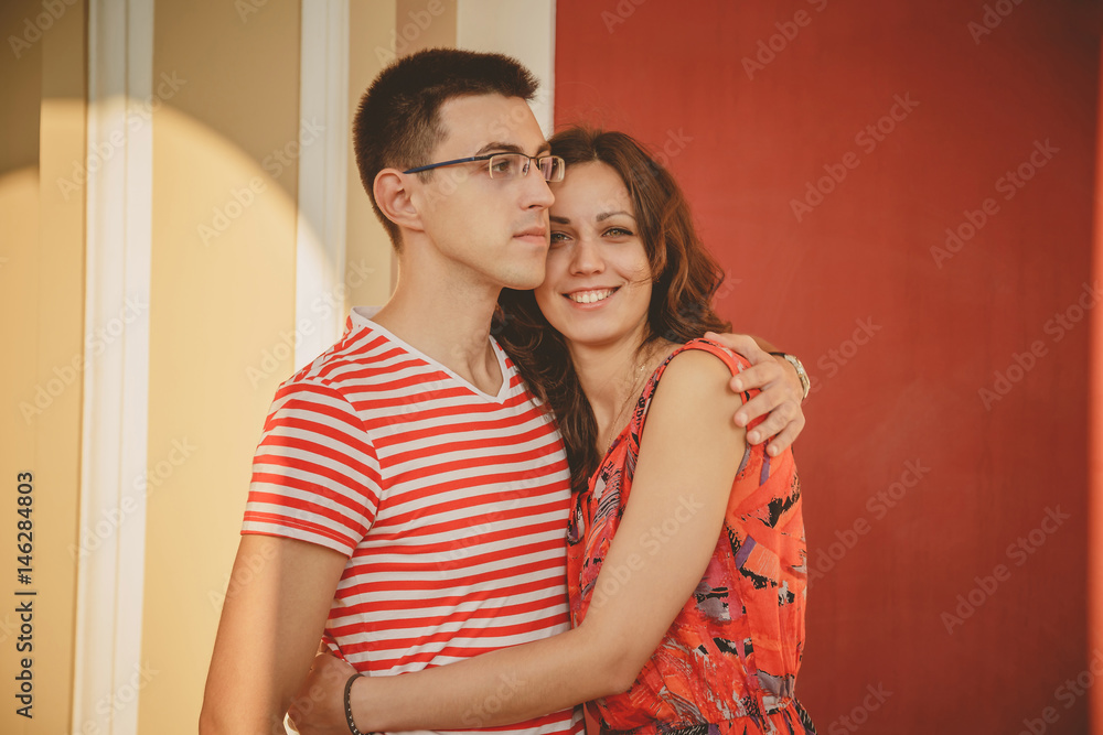 Beautiful romantic couple in love. Happy smiling couple in red looking at camera. Portrait of a young people hugging Beautiful romantic couple in love. Happy smiling couple in red looking at camera. Portrait of a young people hugging