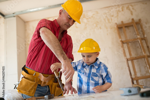 Worthy grandfather and grandson in a carpenter's workshop