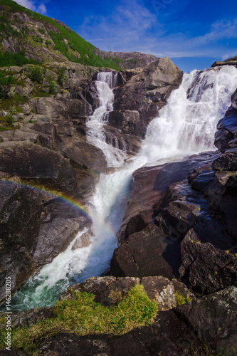 Rainbow and waterfall in the mountains valley in Norway