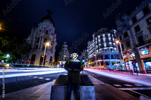 Man with computer Gran Via Madrid long exposure.