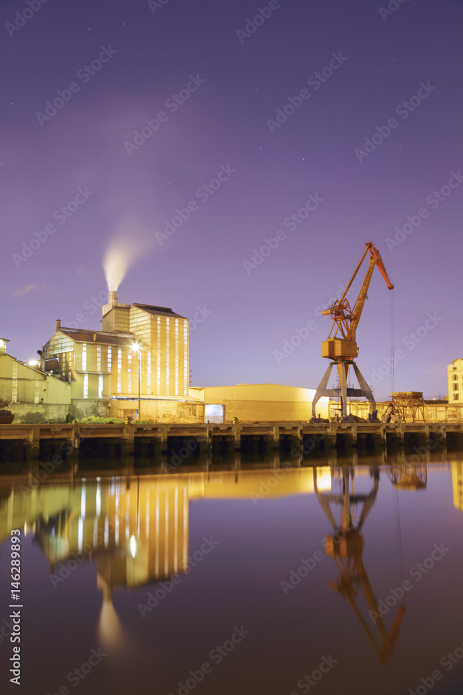 View at evening of the Nervion river near the city of Bilbao Basque Country Spain. Industrial port area with crane and factory in the district of Zorroza.