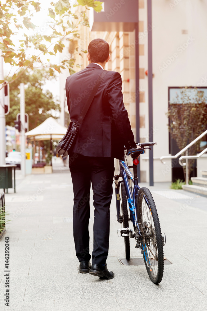 Obraz premium Young businessmen with a bike