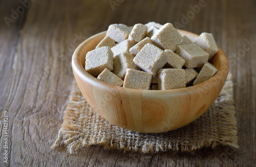 Sugar cubes in wood bowl on wood table